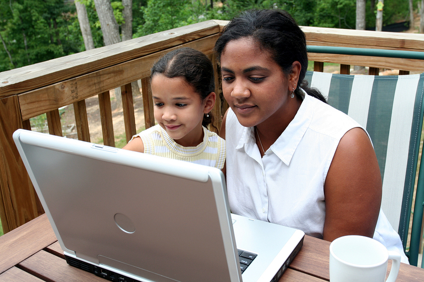 Mother and daughter looking at a laptop.